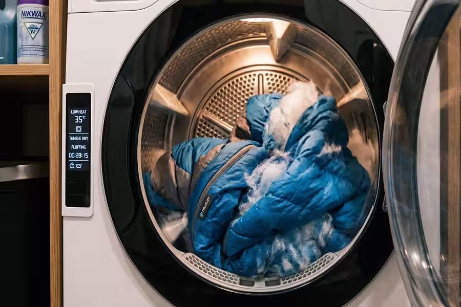 Fluffing polyester sleeping bag insulation during low heat tumble drying