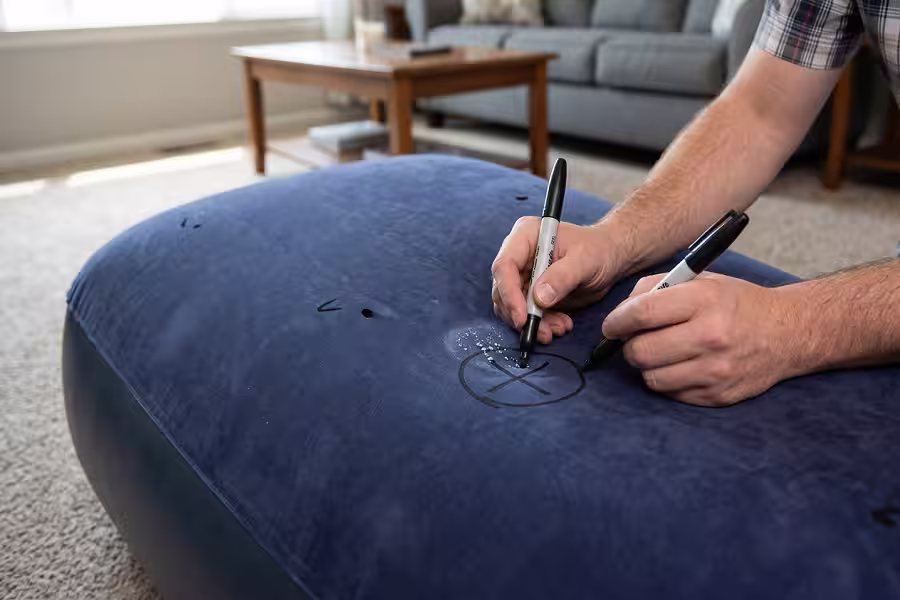 Marking the leaky location on an air mattress with a marker